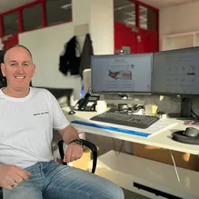 Ein Vertriebsmitarbeiter sitzend am Bürotisch